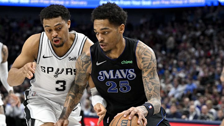 Feb 14, 2024; Dallas, Texas, USA; Dallas Mavericks forward P.J. Washington (25) keeps the ball away from San Antonio Spurs forward Keldon Johnson (3) during the second quarter at the American Airlines Center. Mandatory Credit: Jerome Miron-Imagn Images