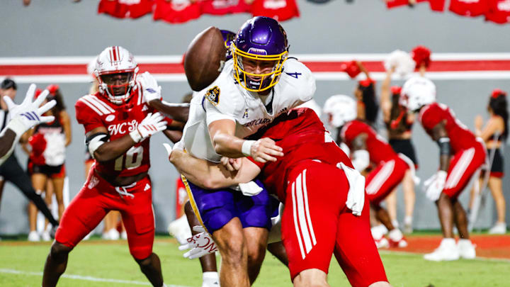 Aug 28, 2025; Raleigh, North Carolina, USA; East Carolina Pirates quarterback Katin Houser (4) passes the ball to running back Marlon Gunn Jr. (21) during the second half of the game against North Carolina State Wolfpack at Carter-Finley Stadium. Mandatory Credit: Jaylynn Nash-Imagn Images Aug 28, 2025; Raleigh, North Carolina, USA; East Carolina Pirates quarterback Katin Houser (4) passes the ball to running back Marlon Gunn Jr. (21) during the second half of the game against North Carolina State Wolfpack at Carter-Finley Stadium. Mandatory Credit: Jaylynn Nash-Imagn Images