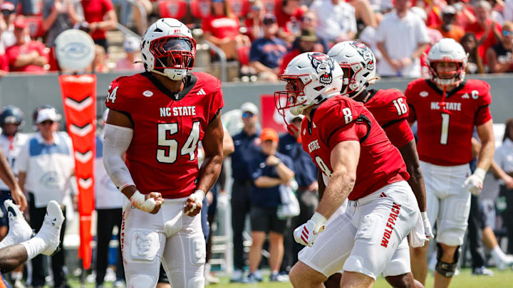 Sep 6, 2025; Raleigh, North Carolina, USA; North Carolina State Wolfpack offensive lineman Rico Jackson (64) celebrates a tackle against Virginia Cavaliers running back J'Mari Taylor (3) during the first half of the game at Carter-Finley Stadium. Mandatory Credit: Jaylynn Nash-Imagn Images Sep 6, 2025; Raleigh, North Carolina, USA; North Carolina State Wolfpack offensive lineman Rico Jackson (64) celebrates a tackle against Virginia Cavaliers running back J'Mari Taylor (3) during the first half of the game at Carter-Finley Stadium. Mandatory Credit: Jaylynn Nash-Imagn Images