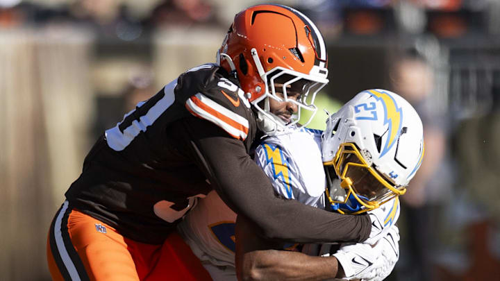 Nov 3, 2024; Cleveland, Ohio, USA; Los Angeles Chargers running back J.K. Dobbins (27) runs the ball as Cleveland Browns linebacker Devin Bush (30) tackles him during the second quarter at Huntington Bank Field. Mandatory Credit: Scott Galvin-Imagn Images