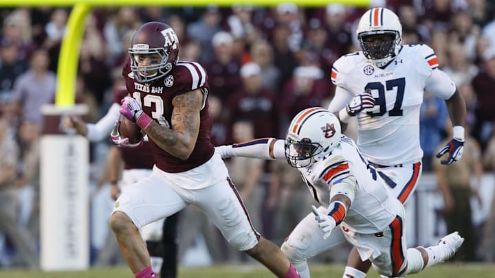 Texas A&M Aggies wide receiver Mike Evans (13) attempts to elude Auburn Tigers linebacker Kris Frost (right) during the second half at Kyle Field. Tigers won 45-41.
