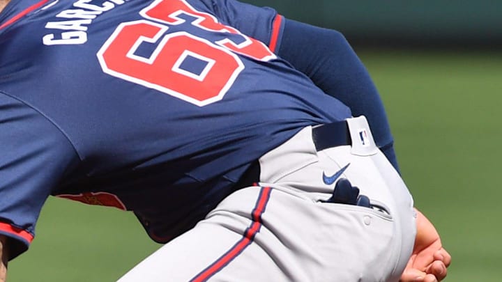 Braves infielder Leury Garcia (#63) scoops up a ground ball during a fielding drill Tuesday, Feb.