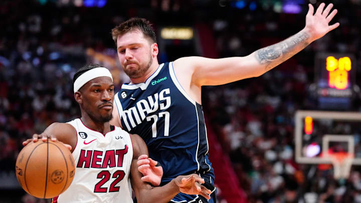 Apr 1, 2023; Miami, Florida, USA; Miami Heat forward Jimmy Butler (22) dribbles the ball past Dallas Mavericks guard Luka Doncic (77) during the second quarter at Miami-Dade Arena. Mandatory Credit: Rich Storry-Imagn Images