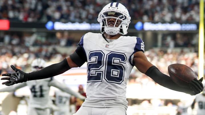 Oct 19, 2025; Arlington, Texas, USA; Dallas Cowboys cornerback Daron Bland (26) carries the ball after an interception for a touchdown against the Washington Commanders during the third quarter of the game at AT&T Stadium. Mandatory Credit: Kevin Jairaj-Imagn Images