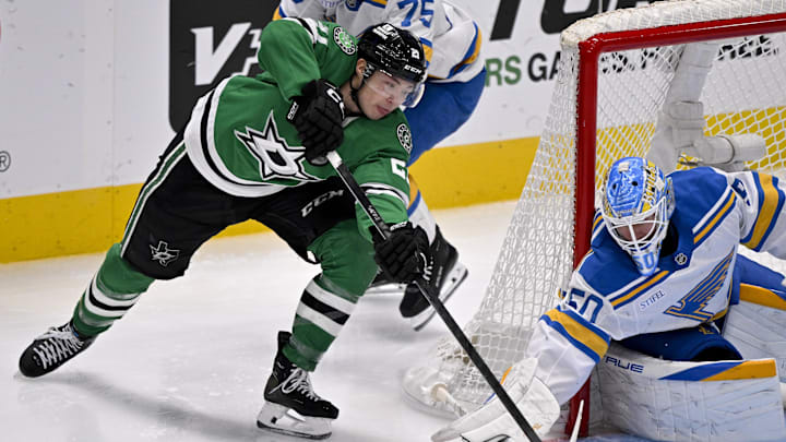 Feb 4, 2026; Dallas, Texas, USA; Dallas Stars left wing Jason Robertson (21) attempts to poke the puck past St. Louis Blues defenseman Tyler Tucker (75) and goaltender Jordan Binnington (50) during the third period at the American Airlines Center. Mandatory Credit: Jerome Miron-Imagn Images