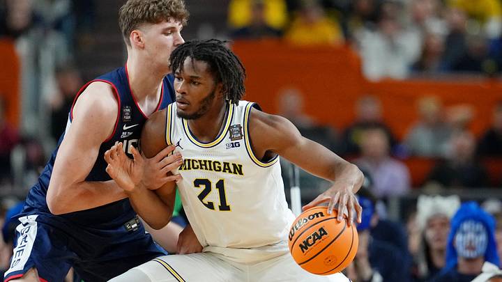 Apr 6, 2026; Indianapolis, IN, USA; Michigan Wolverines forward Morez Johnson Jr. (21) controls the ball against UConn Huskies center Eric Reibe (12) during the first half in the national championship of the Final Four of the men's 2026 NCAA Tournament between the and the Michigan Wolverines at Lucas Oil Stadium. Mandatory Credit: Bob Donnan-Imagn Images Apr 6, 2026; Indianapolis, IN, USA; Michigan Wolverines forward Morez Johnson Jr. (21) controls the ball against UConn Huskies center Eric Reibe (12) during the first half in the national championship of the Final Four of the men's 2026 NCAA Tournament between the and the Michigan Wolverines at Lucas Oil Stadium. Mandatory Credit: Bob Donnan-Imagn Images