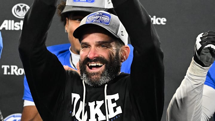 Dec 6, 2025; Charlotte, NC, USA; Duke Blue Devils head coach Manny Diaz lifts the ACC trophy with offensive lineman Justin Pickett (77) and defensive tackle Aaron Hall (99) after defeating the Virginia Cavaliers at the 2025 ACC Championship game at Bank of America Stadium. Mandatory Credit: Bob Donnan-Imagn Images