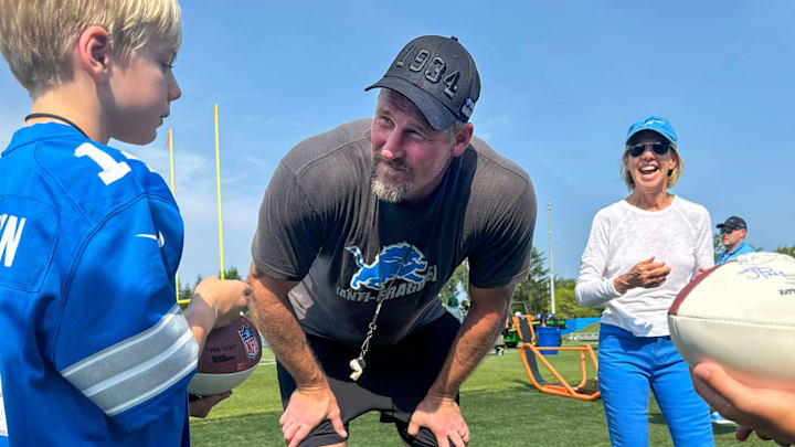 Head Coach Dan Campbell stops to talk to young fans while Detroit Lions Owner and Chair Sheila Ford Hamp looks on Head Coach Dan Campbell stops to talk to young fans while Detroit Lions Owner and Chair Sheila Ford Hamp looks on