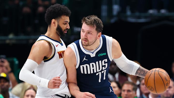 Mar 17, 2024; Dallas, Texas, USA;  Dallas Mavericks guard Luka Doncic (77) controls the ball as Denver Nuggets guard Jamal Murray (27) defends during the first quarter at American Airlines Center. Mandatory Credit: Kevin Jairaj-Imagn Images