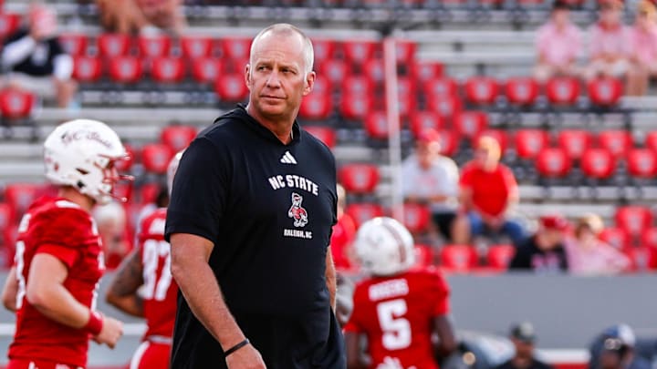 Aug 28, 2025; Raleigh, North Carolina, USA; North Carolina State Wolfpack head coach Dave Doeren walks among his players during the warmups prior to the game against East Carolina Pirates at Carter-Finley Stadium. Mandatory Credit: Jaylynn Nash-Imagn Images