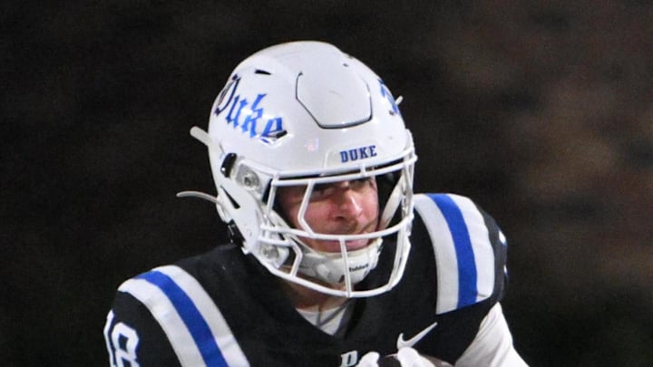 Nov 29, 2025; Durham, North Carolina, USA;  Duke Blue Devils wide receiver Cooper Barkate (18) runs the ball against Wake Forest Demon Deacons defensive back Davaughn Patterson (5) during the third quarter at Wallace Wade Stadium. Mandatory Credit: Zachary Taft-Imagn Images