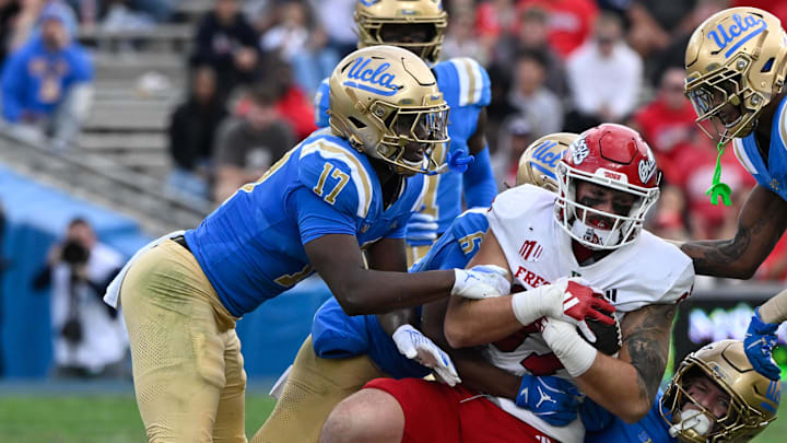 Nov 30, 2024; Pasadena, California, USA; UCLA Bruins linebacker Jalen Woods (17), defensive back Jaylin Davies (6), linebacker Carson Schwesinger (49), and UCLA Bruins defensive back Bryan Addison (4) tackle Fresno State Bulldogs tight end Jake Tarwater (87) during the third quarter at Rose Bowl. Mandatory Credit: Robert Hanashiro-Imagn Images