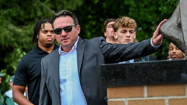 Michigan State's head coach Jonathan Smith touches the foot of the Sparty statue before the game against Florida Atlantic on Friday, Aug. 30, 2024, outside Spartan Stadium in East Lansing.