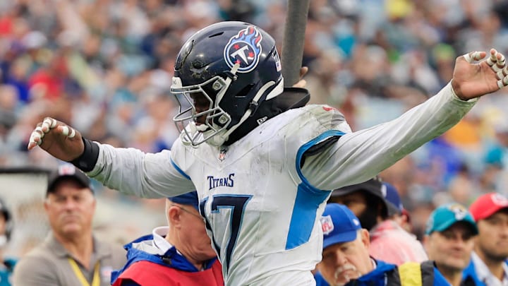 Tennessee Titans linebacker Jerome Baker leaps to avoid collision with Jacksonville Jaguars quarterback Mac Jones.
