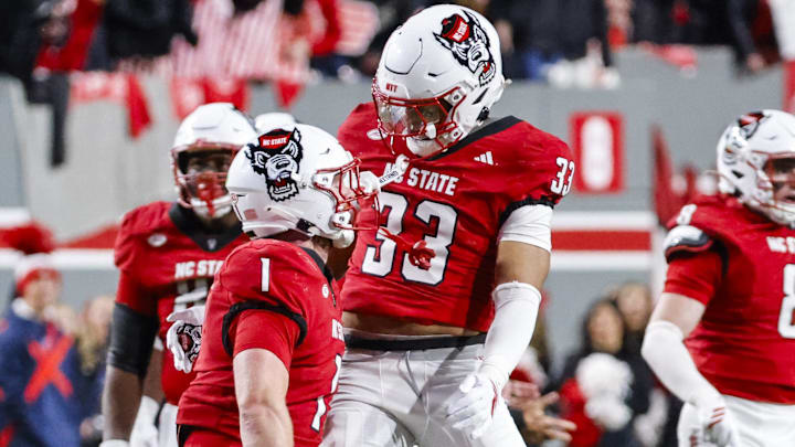 Nov 29, 2025; Raleigh, North Carolina, USA; NC State Wolfpack linebacker Caden Fordham (1) reacts to his tackle with linebacker Jr. Kenny Soares (33) during the first half of the game against the North Carolina Tar Heels at Carter-Finley Stadium.  Mandatory Credit: Jaylynn Nash-Imagn Images