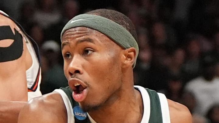 Mar 30, 2025; Atlanta, GA, USA; Michigan State Spartans guard Tre Holloman (5) drives against Auburn Tigers center Dylan Cardwell (44) during the first half in the South Regional final of the 2025 NCAA tournament at State Farm Arena. Mandatory Credit: Dale Zanine-Imagn Images