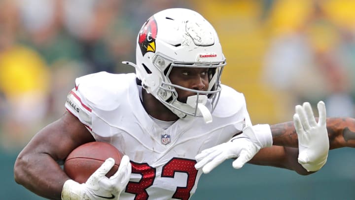 Arizona Cardinals running back Trey Benson (33) runs for a first down against Green Bay Packers cornerback Keisean Nixon (25) in the third quarter during their football game Sunday, October 13, 2024, at Lambeau Field in Green Bay, Wisconsin. Arizona Cardinals running back Trey Benson (33) runs for a first down against Green Bay Packers cornerback Keisean Nixon (25) in the third quarter during their football game Sunday, October 13, 2024, at Lambeau Field in Green Bay, Wisconsin.