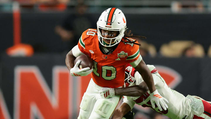Oct 17, 2025; Miami Gardens, Florida, USA; Miami Hurricanes wide receiver Malachi Toney (10) carries the football against Louisville Cardinals defensive back Tayon Holloway (25) during the fourth quarter at Hard Rock Stadium. Mandatory Credit: Sam Navarro-Imagn Images