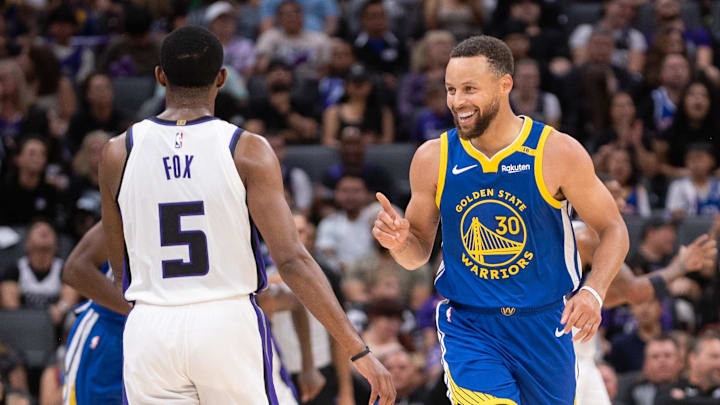 Oct 9, 2024; Sacramento, California, USA; Golden State Warriors guard Stephen Curry (30) motions to Sacramento Kings guard De'Aaron Fox (5) after scoring during the second quarter at Golden 1 Center. 