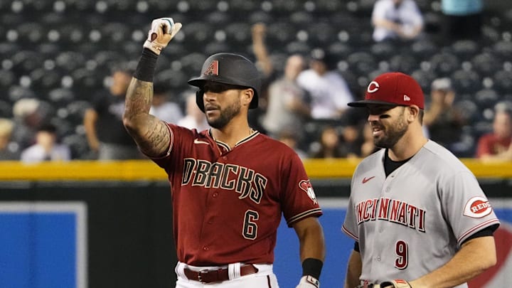 Jun 15, 2022; Phoenix, Arizona, USA; Arizona Diamondbacks David Peralta (6) reacts next to Cincinnati Reds first baseman Mike Moustakas (9) after hitting a double in the second inning at Chase Field.

Mlb Reds At Diamondbacks