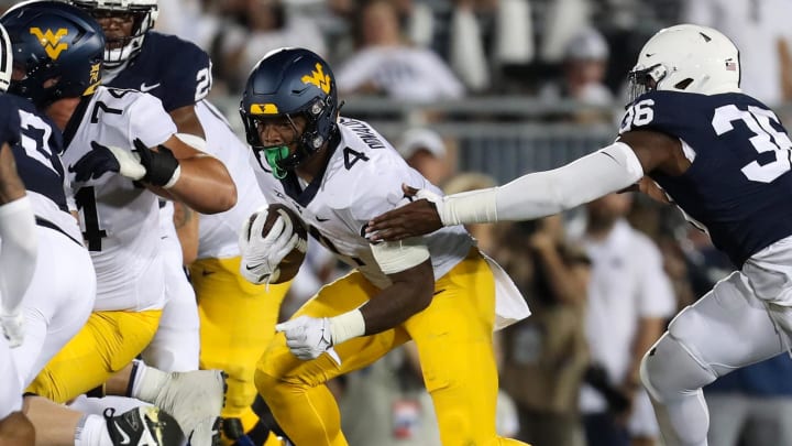 Sep 2, 2023; University Park, Pennsylvania, USA; West Virginia Mountaineers running back CJ Donaldson Jr. (4) runs with the ball while breaking a tackle from Penn State Nittany Lions defensive end Zuriah Fisher (36) during the third quarter at Beaver Stadium. Penn State defeated West Virginia 38-15. Sep 2, 2023; University Park, Pennsylvania, USA; West Virginia Mountaineers running back CJ Donaldson Jr. (4) runs with the ball while breaking a tackle from Penn State Nittany Lions defensive end Zuriah Fisher (36) during the third quarter at Beaver Stadium. Penn State defeated West Virginia 38-15.