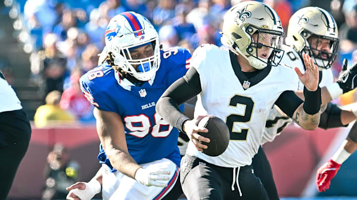 Sep 28, 2025; Orchard Park, New York, USA; New Orleans Saints quarterback Spencer Rattler (2) runs from pressure from Buffalo Bills defensive tackle TJ. Sanders (98) and defensive end AJ. Epenesa (57) in the fourth quarter at Highmark Stadium. 