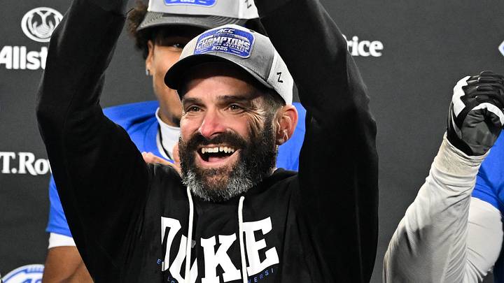 Dec 6, 2025; Charlotte, NC, USA; Duke Blue Devils head coach Manny Diaz lifts the ACC trophy with offensive lineman Justin Pickett (77) and defensive tackle Aaron Hall (99) after defeating the Virginia Cavaliers at the 2025 ACC Championship game at Bank of America Stadium. Mandatory Credit: Bob Donnan-Imagn Images