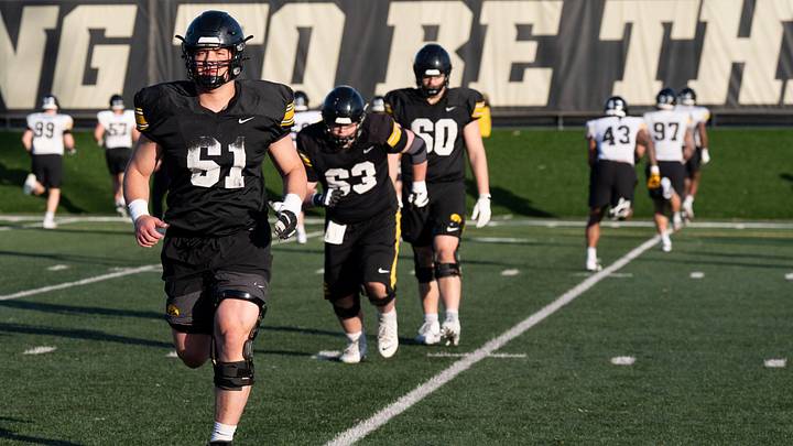 Iowa’s Cannon Leonard (75), Cael Winter (61) and others warm up during practice April 9, 2026 in Iowa City, Iowa.