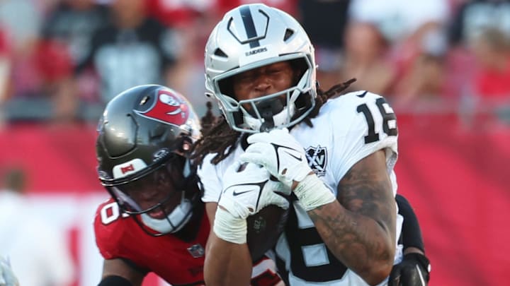 Dec 8, 2024; Tampa, Florida, USA; Las Vegas Raiders wide receiver Jakobi Meyers (16) runs with the ball as Tampa Bay Buccaneers safety Kaevon Merriweather (26) defends during the second half at Raymond James Stadium. Mandatory Credit: Kim Klement Neitzel-Imagn Images