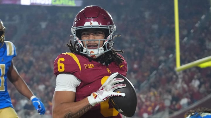 Nov 29, 2025; Los Angeles, California, USA; Southern California Trojans wide receiver Makai Lemon (6) catches a 32-yard touchdown pass against UCLA Bruins defensive back Kanye Clark (1) in the second half at United Airlines Field at Los Angeles Memorial Coliseum. Mandatory Credit: Kirby Lee-Imagn Images