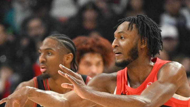 Toronto Raptors guard Immanuel Quickley passes the ball away from Philadelphia 76ers guard Tyrese Maxey.