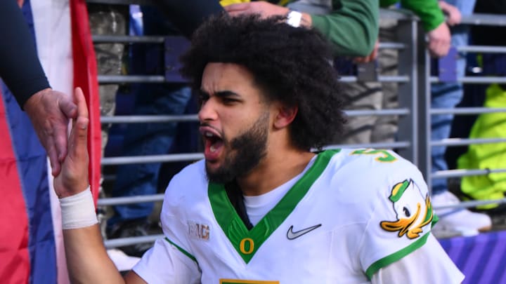 Nov 29, 2025; Seattle, Washington, USA; Oregon Ducks quarterback Dante Moore (5) celebrates with fans after Oregon defeated the Washington Huskies at Husky Stadium. Mandatory Credit: Steven Bisig-Imagn Images