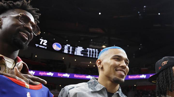 Detroit Lions wide receiver Amon-Ra St. Brown and running back Jahmyr Gibbs hold up jerseys during Pistons game