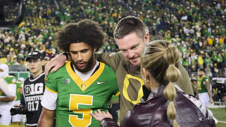 Nov 14, 2025; Eugene, Oregon, USA; Oregon Ducks quarterback Dante Moore (5) and head coach Dan Lanning talk to a reporter after a game against the Minnesota Golden Gophers at Autzen Stadium. Mandatory Credit: Troy Wayrynen-Imagn Images