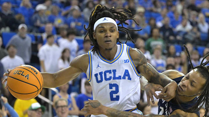 Feb 8, 2025; Los Angeles, California, USA;  UCLA Bruins guard Dylan Andrews (2) controls the ball away from Penn State Nittany Lions guard Ace Baldwin Jr. (1) in the second half at Pauley Pavilion presented by Wescom. Mandatory Credit: Jayne Kamin-Oncea-Imagn Images