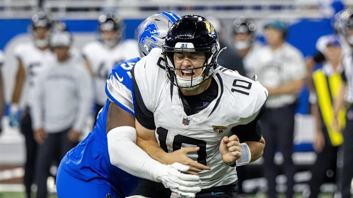 Nov 17, 2024; Detroit, Michigan, USA; Jacksonville Jaguars quarterback Mac Jones (10) passes the ball and is pressured by Detroit Lions defensive end Levi Onwuzurike (91) during the second half at Ford Field. Mandatory Credit: David Reginek-Imagn Images