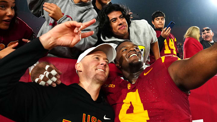 Nov 29, 2025; Los Angeles, California, USA; Southern California Trojans head coach Lincoln Riley (right) and defensive tackle Jahkeem Stewart (4) pose with fans after the game against the UCLA Bruins at United Airlines Field at Los Angeles Memorial Coliseum. 