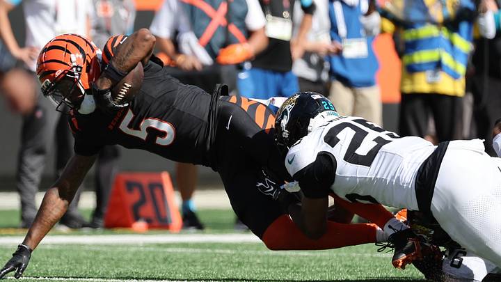 Oct 4, 2026; Cincinnati, Ohio, USA;  Cincinnati Bengals wide receiver Tee Higgins (5) is tackled by Jacksonville Jaguars safety Rayuan Lane III (25) during the fourth quarter at Paycor Stadium.  Mandatory Credit: Joseph Maiorana-Imagn Images