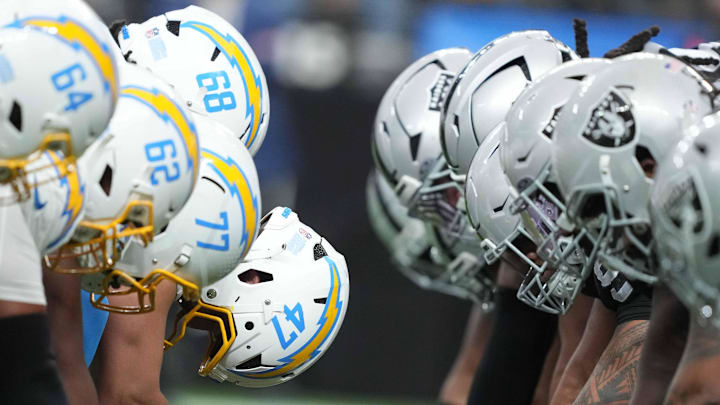 Jan 5, 2025; Paradise, Nevada, USA; Helmets at the line of scrimmage as Los Angeles Chargers long snapper Josh Harris (47) snaps the ball against the Las Vegas Raiders at Allegiant Stadium. Mandatory Credit: Kirby Lee-Imagn Images
