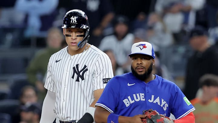 Oct 8, 2025; Bronx, New York, USA; New York Yankees right fielder Aaron Judge (99) leads off first base against Toronto Blue Jays first baseman Vladimir Guerrero Jr. (27) during the ninth inning of game four of the ALDS round of the 2025 MLB playoffs at Yankee Stadium. Mandatory Credit: Brad Penner-Imagn Images