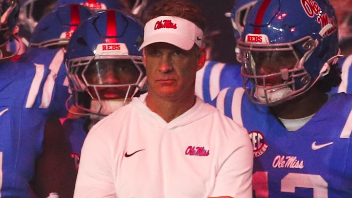 Mississippi Rebels head coach Lane Kiffin stands with his players before a game against the Florida Gators Mississippi Rebels head coach Lane Kiffin stands with his players before a game against the Florida Gators