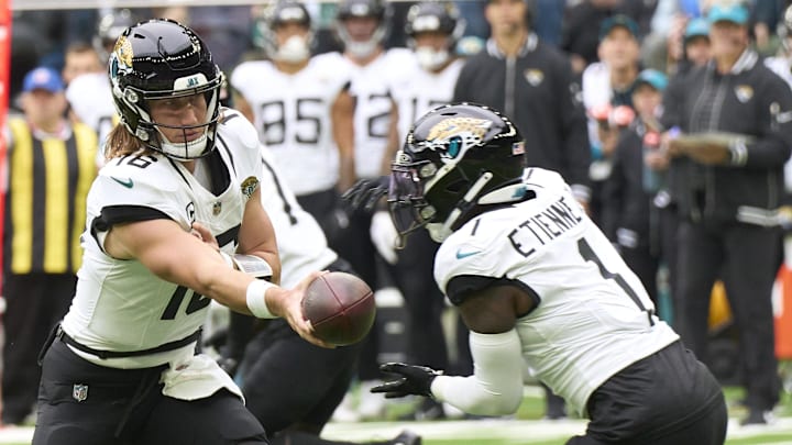 Oct 13, 2024; London, United Kingdom; Jacksonville Jaguars quarterback Trevor Lawrence (16) hands off to Jacksonville Jaguars running back Travis Etienne Jr. (1) during the first half of an NFL International Series game at Tottenham Hotspur Stadium. Mandatory Credit: Peter van den Berg-Imagn Images