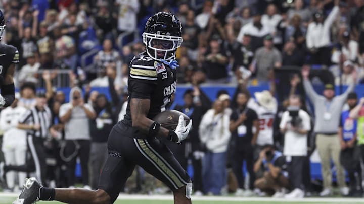 Dec 28, 2024; San Antonio, TX, USA; Colorado Buffaloes wide receiver Travis Hunter (12) runs with the ball and scores a touchdown during the third quarter against the Brigham Young Cougars at Alamodome. Mandatory Credit: Troy Taormina-Imagn Images