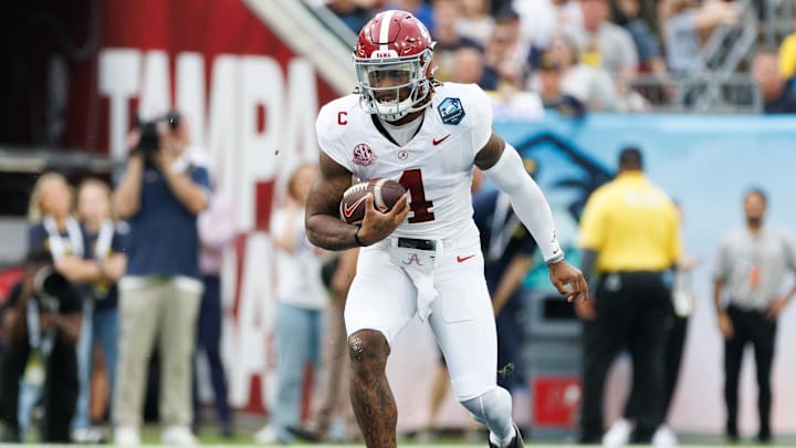 Dec 31, 2024; Tampa, FL, USA; Alabama Crimson Tide quarterback Jalen Milroe (4) runs with the ball against the Michigan Wolverines during the first half at Raymond James Stadium.