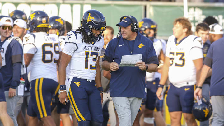Sep 6, 2025; Athens, Ohio, USA; West Virginia Mountaineers head coach Rich Rodriguez talks with West Virginia Mountaineers quarterback Jaylen Henderson (13) during the fourth quarter against the Ohio Bobcats at Peden Stadium. 