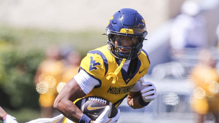 Aug 30, 2025; Morgantown, West Virginia, USA; West Virginia Mountaineers wide receiver Cam Vaughn (4) catches a ball and runs for extra yards during the first quarter against the Robert Morris Colonials at Milan Puskar Stadium. Mandatory Credit: Ben Queen-Imagn Images