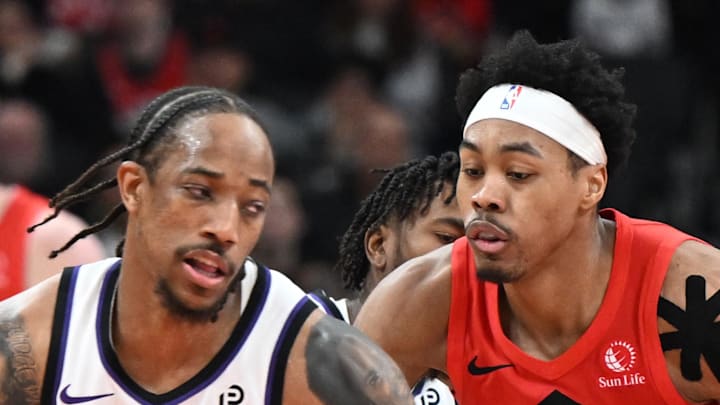 Sacramento Kings forward DeMar DeRozan dribbles the ball as Toronto Raptors forward Scottie Barnes defends.