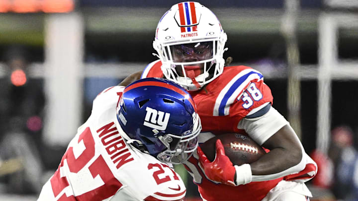 Dec 1, 2025; Foxborough, Massachusetts, USA; New England Patriots running back Rhamondre Stevenson (38) runs the ball against New York Giants safety Tyler Nubin (27) during the fourth quarter at Gillette Stadium.