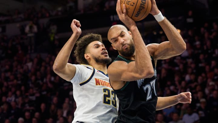 Apr 25, 2026; Minneapolis, Minnesota, USA; Minnesota Timberwolves center Rudy Gobert (27) rebounds over Denver Nuggets forward Cam Johnson (23) in the third quarter at Target Center.