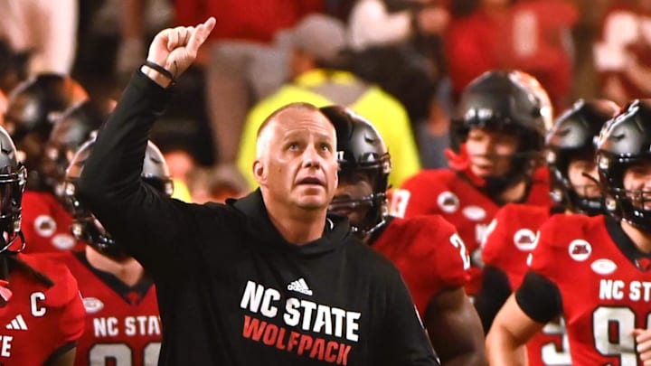 Nov 4, 2023; Raleigh, North Carolina, USA; North Carolina State Wolfpack head coach Dave Doeren (center) lead his team onto the field prior to a game against the Miami Hurricanes at Carter-Finley Stadium. Mandatory Credit: Rob Kinnan-Imagn Images